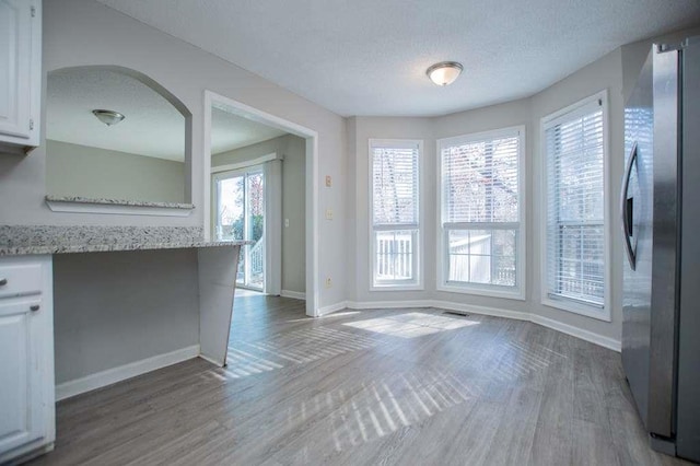 unfurnished dining area featuring hardwood / wood-style floors and a textured ceiling