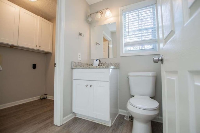 bathroom with vanity, hardwood / wood-style flooring, and toilet