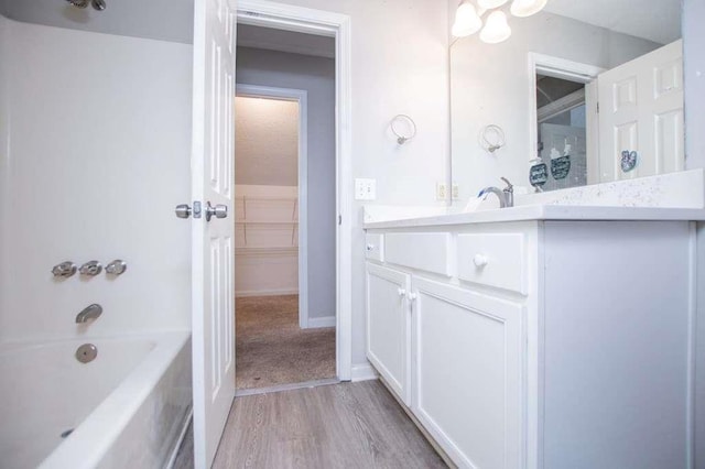 bathroom with hardwood / wood-style flooring, vanity, and shower / washtub combination