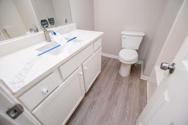 bathroom with vanity, hardwood / wood-style flooring, and toilet