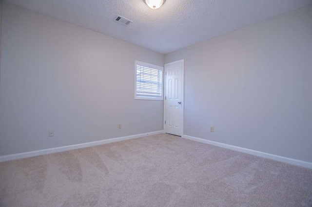 carpeted spare room with a textured ceiling