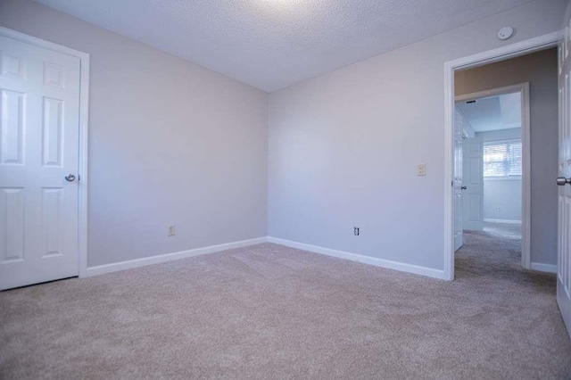 unfurnished room featuring light colored carpet and a textured ceiling