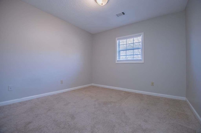 carpeted empty room with a textured ceiling