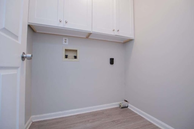 clothes washing area featuring cabinets, hookup for a washing machine, light hardwood / wood-style floors, and hookup for an electric dryer