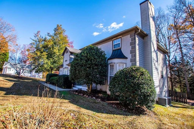 view of home's exterior featuring a lawn and central air condition unit