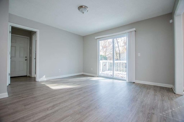 unfurnished room featuring a textured ceiling and light wood-type flooring