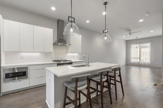 133 City View Ct NE, Atlanta, GA 30308 - kitchen with wall chimney exhaust hood, appliances with stainless steel finishes, modern cabinets, tasteful backsplash, and dark wood-style floors