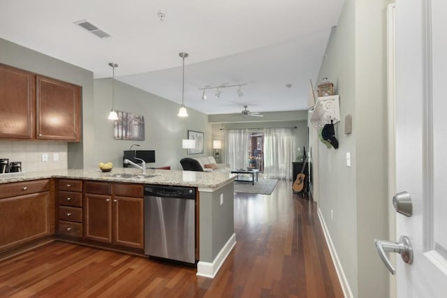 kitchen with light stone countertops, dark hardwood / wood-style floors, stainless steel dishwasher, and kitchen peninsula