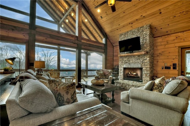 living room with a stone fireplace, ceiling fan, high vaulted ceiling, and a healthy amount of sunlight