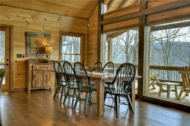 dining area with wooden walls, dark hardwood / wood-style flooring, wooden ceiling, and vaulted ceiling