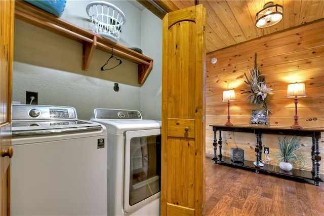 clothes washing area featuring separate washer and dryer, wood walls, wood ceiling, and dark hardwood / wood-style floors