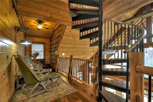 staircase with ceiling fan, wooden ceiling, vaulted ceiling with beams, wood-type flooring, and wooden walls