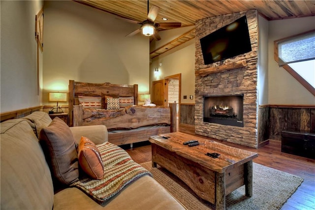 living room with ceiling fan, hardwood / wood-style floors, lofted ceiling, a fireplace, and wood ceiling