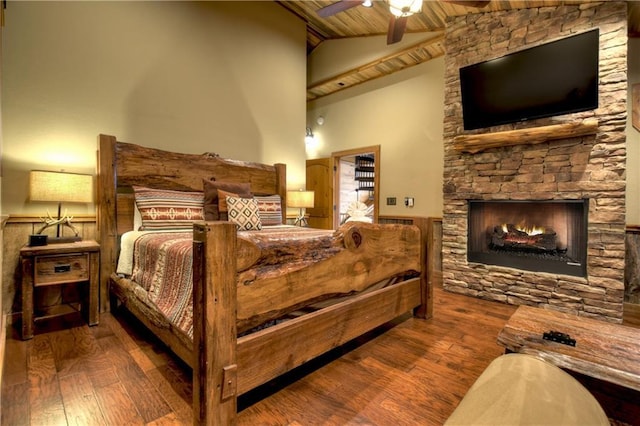 bedroom featuring ceiling fan, hardwood / wood-style flooring, high vaulted ceiling, wooden ceiling, and a fireplace