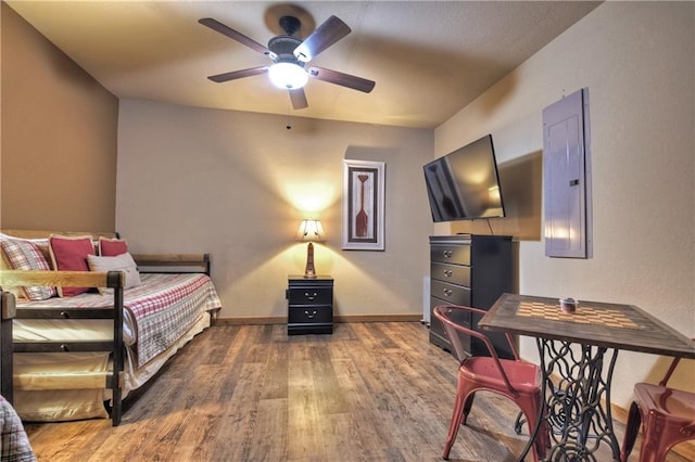 bedroom featuring hardwood / wood-style floors, ceiling fan, and electric panel