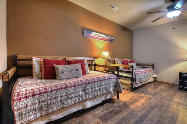 bedroom featuring ceiling fan, dark wood-type flooring, and vaulted ceiling