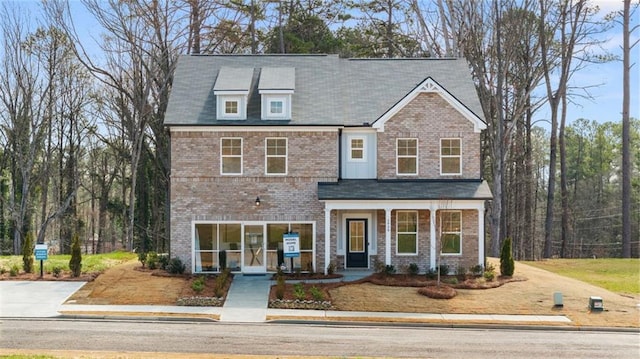 view of front facade featuring covered porch and brick siding