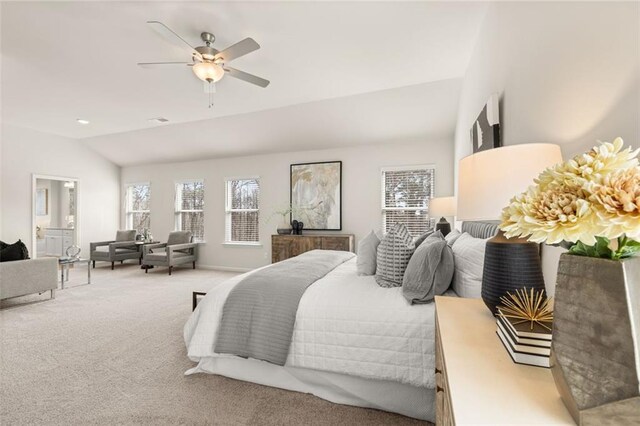 carpeted bedroom with ceiling fan, multiple windows, and lofted ceiling