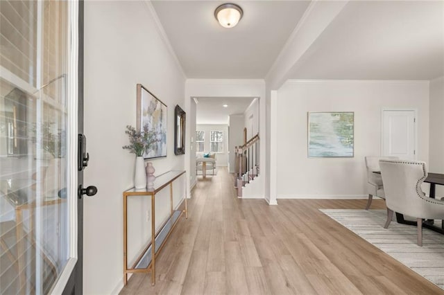entrance foyer featuring ornamental molding, stairway, light wood-style flooring, and baseboards