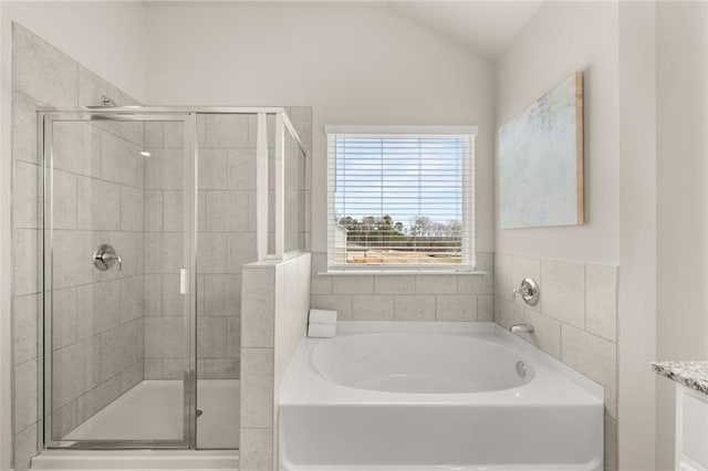 full bathroom featuring a bath, a shower stall, lofted ceiling, and vanity