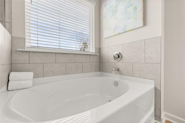 full bath featuring a garden tub and tile walls