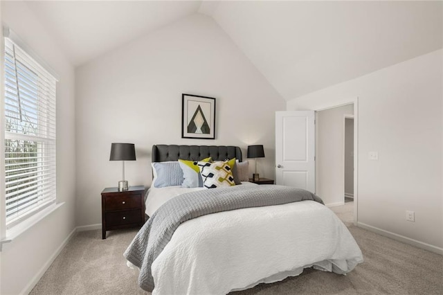 bedroom with vaulted ceiling, light colored carpet, and baseboards