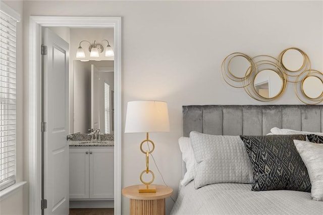 bedroom with a sink, connected bathroom, and multiple windows