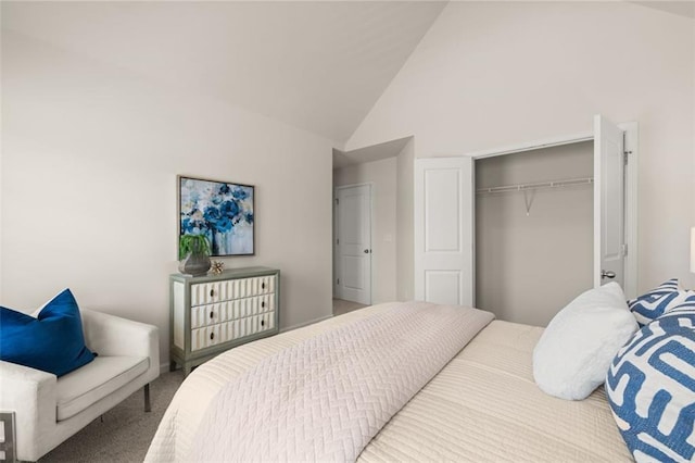 carpeted bedroom featuring a closet and high vaulted ceiling