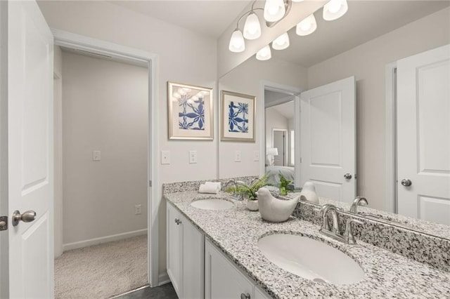 bathroom featuring double vanity, baseboards, and a sink