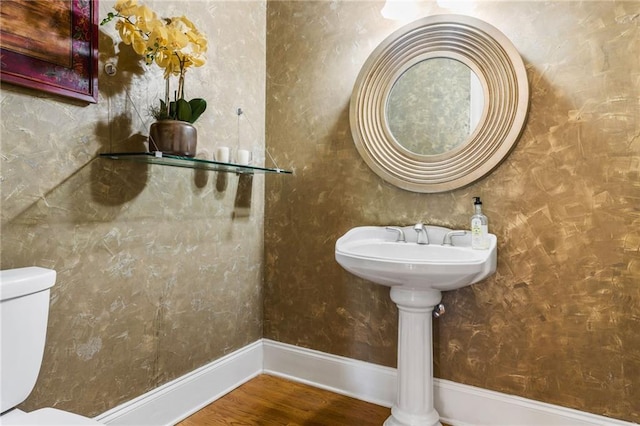 bathroom with hardwood / wood-style flooring and toilet