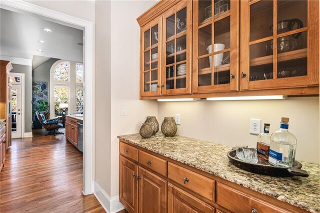 interior space featuring light stone counters, crown molding, stainless steel dishwasher, and dark hardwood / wood-style floors