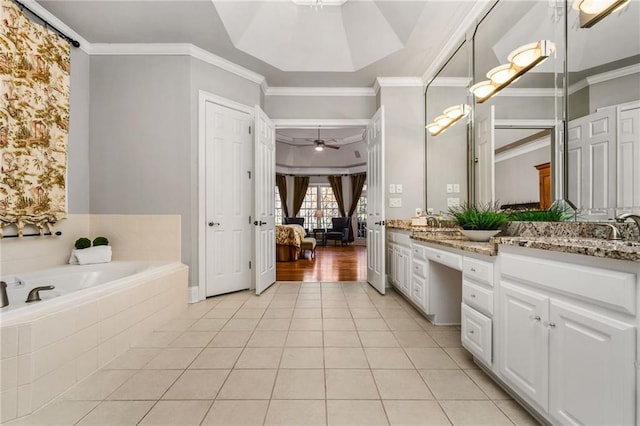 bathroom featuring tile patterned floors, vanity, ceiling fan, crown molding, and a relaxing tiled tub