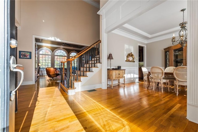 foyer featuring hardwood / wood-style floors, ornamental molding, and an inviting chandelier