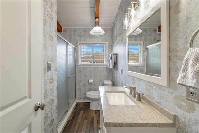 full bath featuring wallpapered walls, a shower stall, and toilet