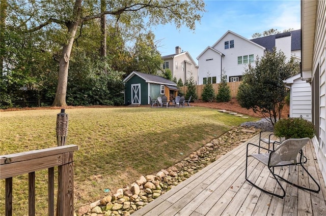 view of yard featuring a storage unit, an outdoor structure, and fence