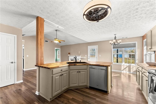 kitchen featuring stainless steel appliances, butcher block counters, sink, and a center island with sink