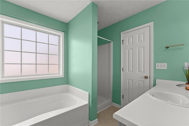 bathroom with vanity, a textured ceiling, and separate shower and tub