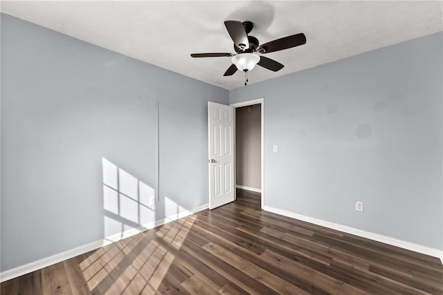 empty room featuring dark hardwood / wood-style flooring and ceiling fan