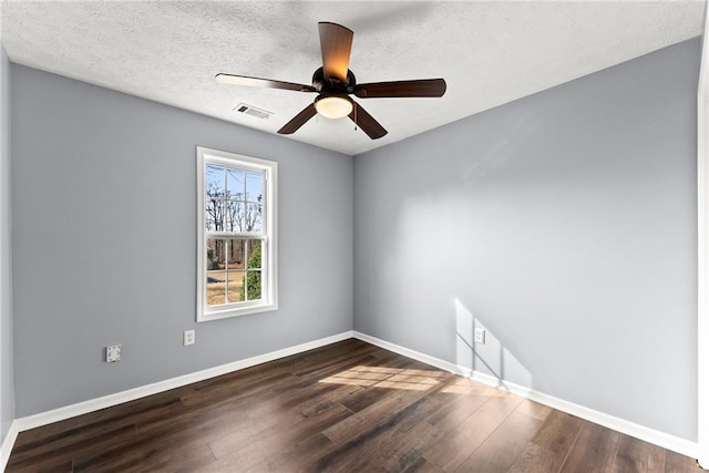 empty room featuring ceiling fan, dark hardwood / wood-style flooring, and a textured ceiling