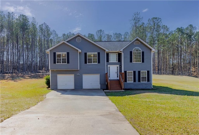 bi-level home with driveway, an attached garage, and a front yard