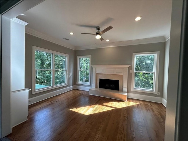 unfurnished living room with dark hardwood / wood-style flooring, ornamental molding, plenty of natural light, and a high end fireplace