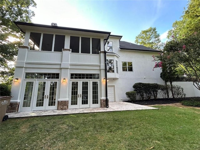 back of property with a patio, a yard, french doors, and a balcony