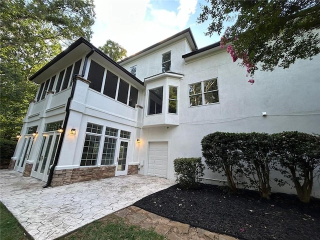 rear view of house with a garage and a patio