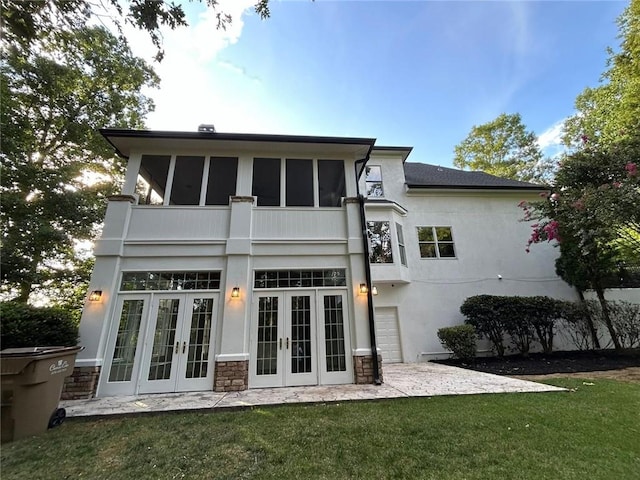 rear view of property with a yard, a patio area, french doors, and a balcony