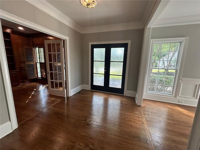 entryway with dark wood-type flooring, ornamental molding, and french doors