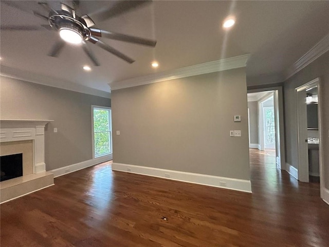 unfurnished living room with dark wood-type flooring, ceiling fan, ornamental molding, and a premium fireplace