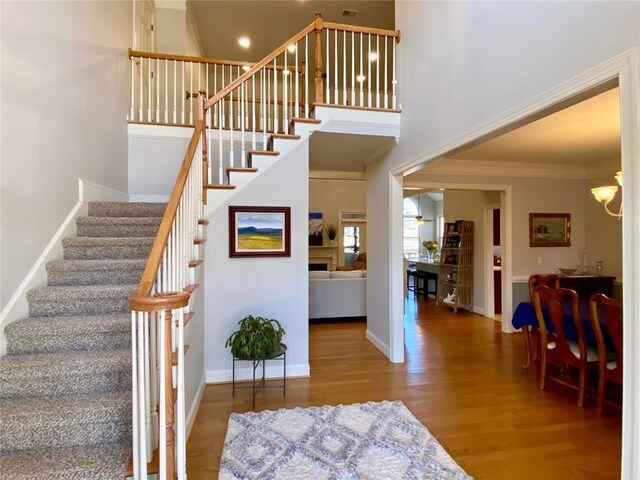 dining area featuring crown molding, an inviting chandelier, and hardwood / wood-style flooring