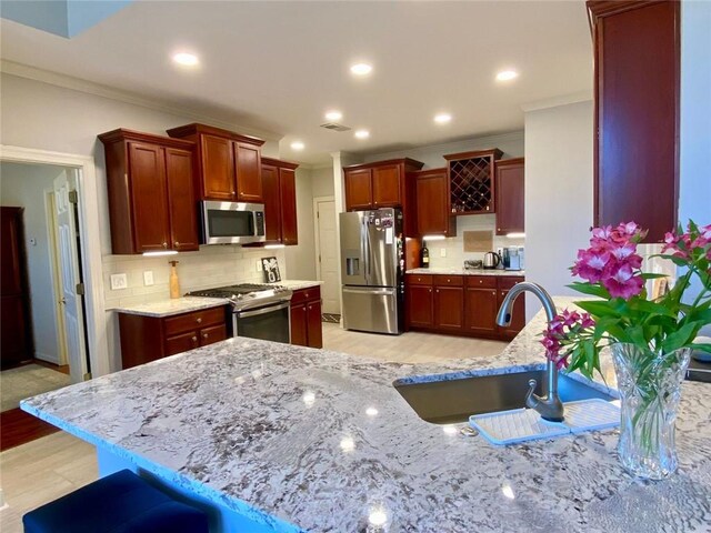 kitchen with lofted ceiling, appliances with stainless steel finishes, sink, and a breakfast bar area