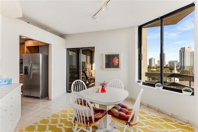2660 Peachtree Rd NW Unit 18G, Atlanta, GA 30305 - dining room with light tile patterned flooring, a skyline view, and rail lighting
