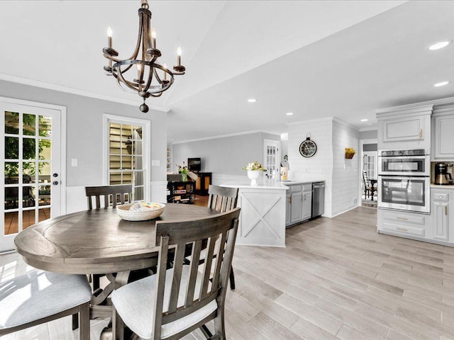 dining room with a chandelier, recessed lighting, crown molding, vaulted ceiling, and light wood finished floors